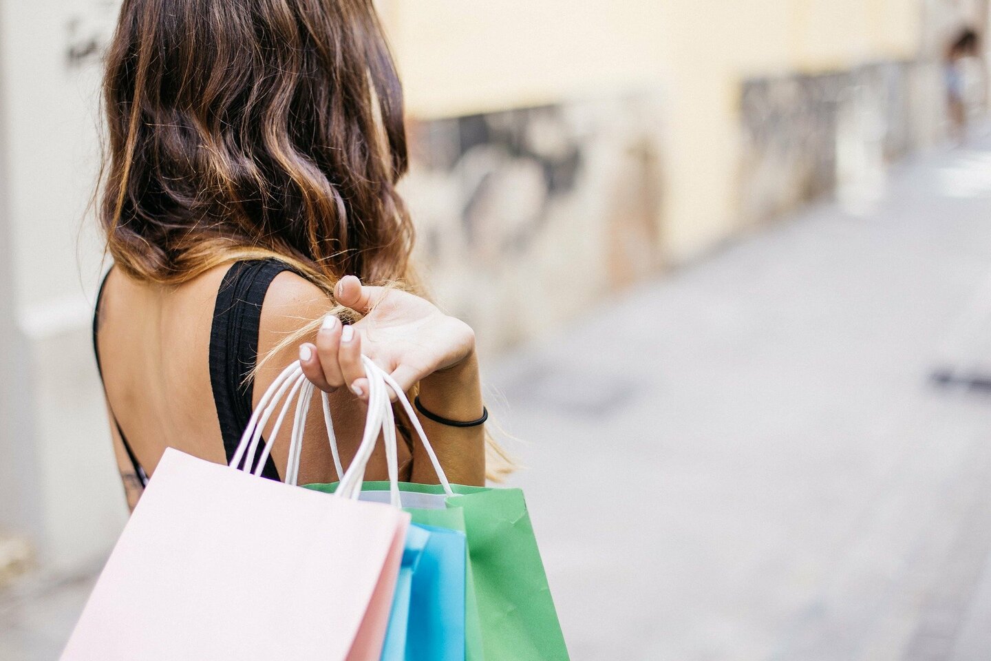 Woman from behind holding shopping bags