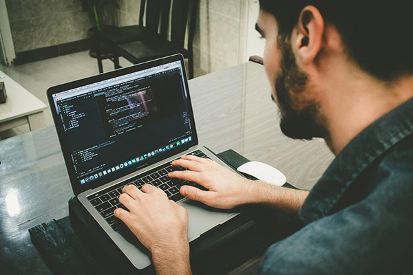 Man coding with a laptop